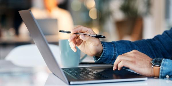 open laptop with hands working 
