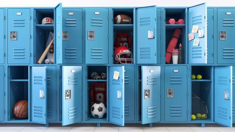 School lockers with open doors and sports equipment. 